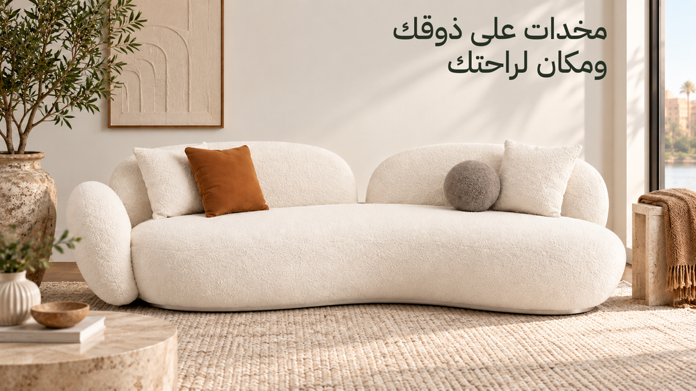 كنبة لوما الفاتحة بمنحنياتها الأصلية ومخدات عند الطرفين، مع مساحة فاضية للقعدة وعنوان مخدات على ذوقك ومكان لراحتك